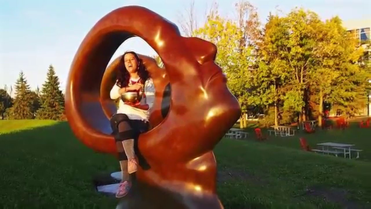 Cumie singing beside a Cirque du Soleil art installation.